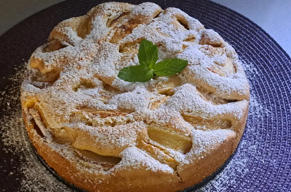 Szybki jabłecznik na oleju, posypany cukrem pudrem i udekorowany listkiem mięty. Idealny na deser.