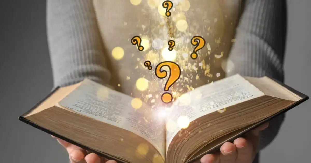 Otwarta księga, z której wylatują złote znaki zapytania i błyskotki. Każdy sobie rzepkę skrobie, szukając odpowiedzi.