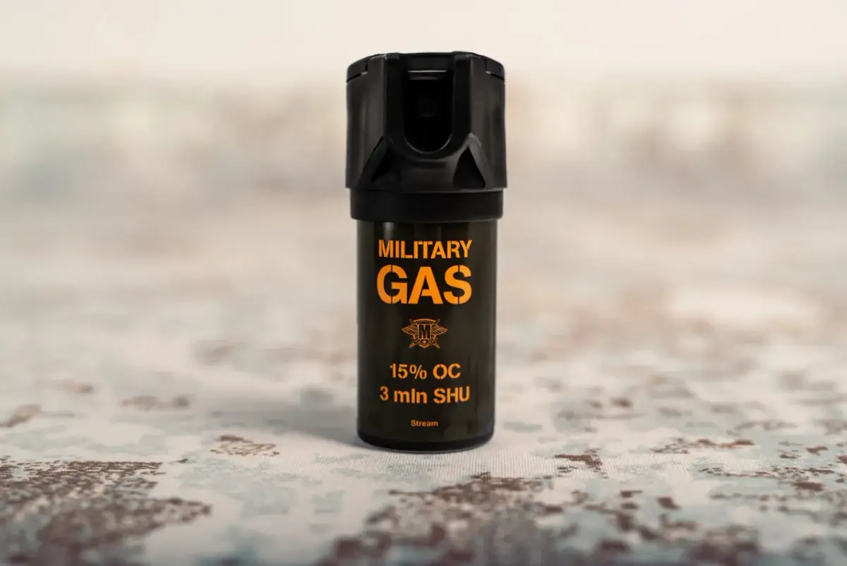 Czarny gaz pieprzowy z pomarańczowym napisem "MILITARY GAS" i informacją "Stream".