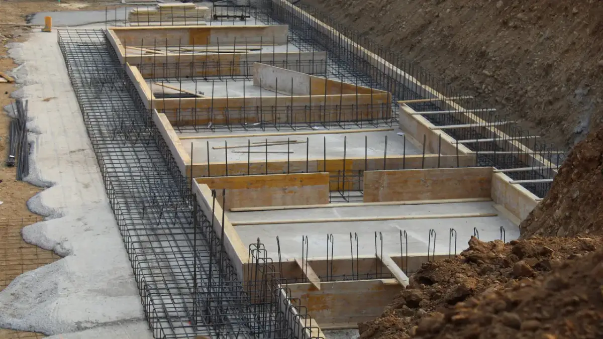 Szkielet zbrojeniowy i szalunki drewniane czekają na beton. Tak wygląda budowa fundamentów krok po kroku.
