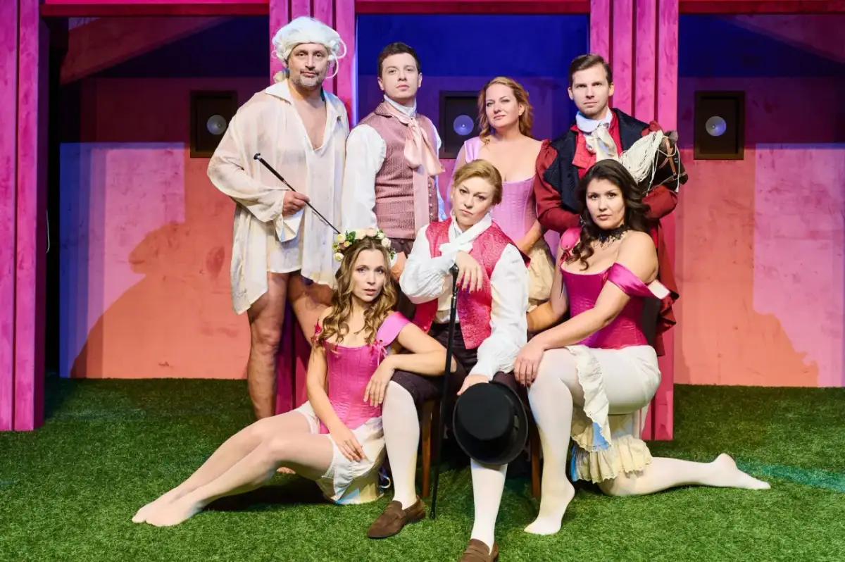 Aktorzy w strojach teatralnych, którzy pracują w teatrze, pozują na scenie.