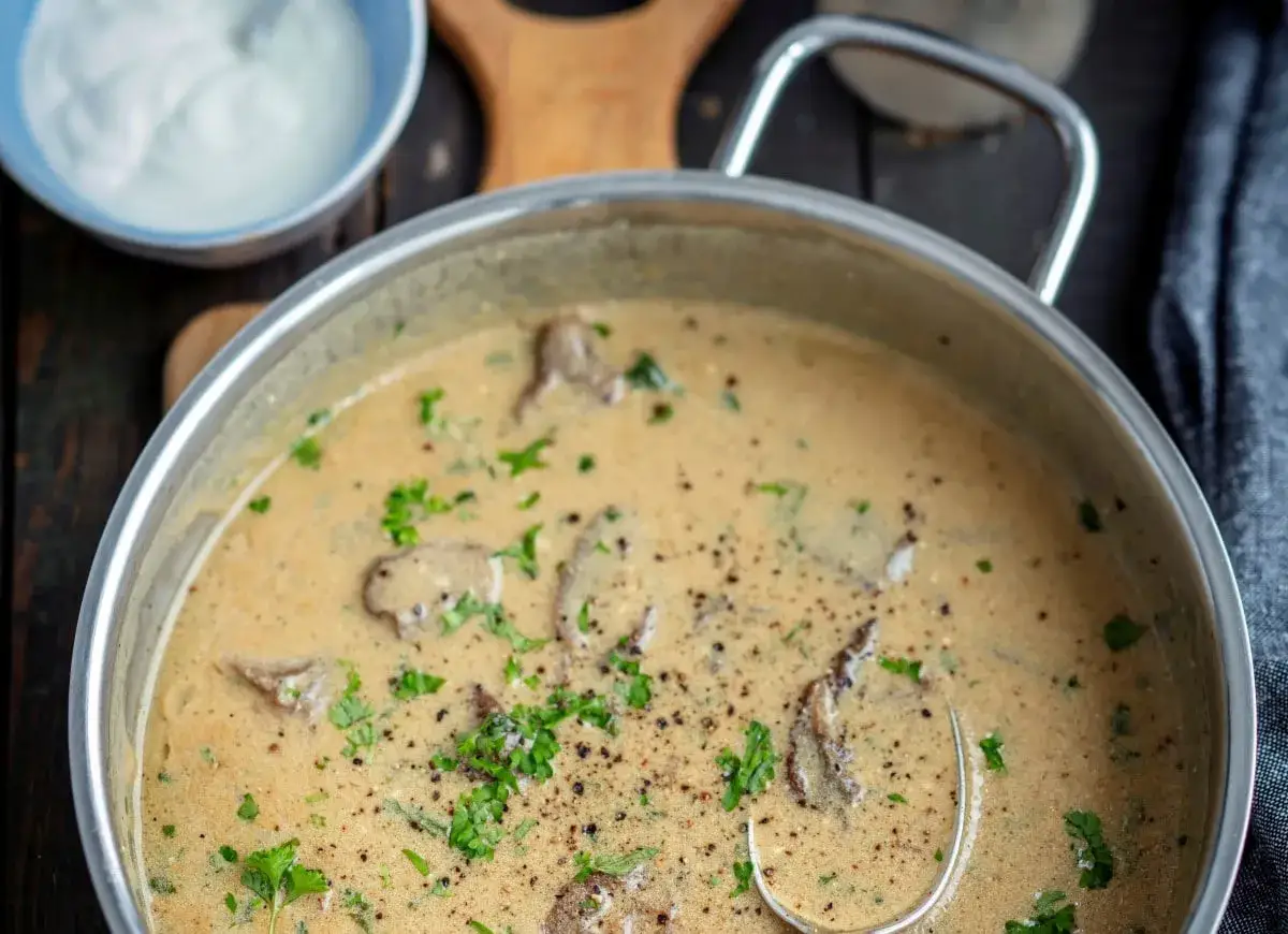 Kremowy sos z grzybów, gotowy do podania. Idealny przykład, jak się robi sos z grzybów, z dodatkiem świeżej natki pietruszki i pieprzu.