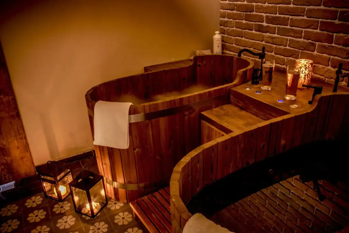 Drewniane wanny SPA z parą, świecami i napojami.