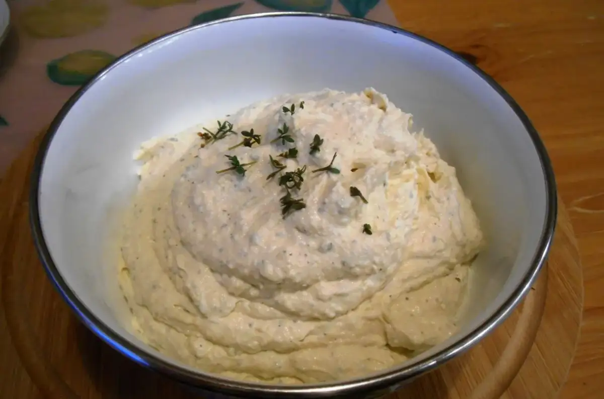 Puszysta pasta jajeczna z chrzanem, udekorowana gałązkami tymianku, w białej misce. Idealna na kanapki.
