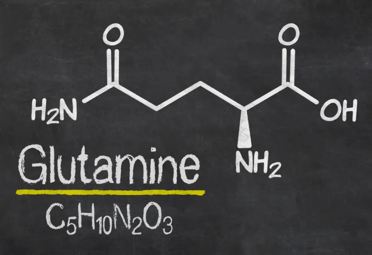 Struktura chemiczna glutaminy z napisem "Glutamine" i wzorem C₅H₁₀N₂O₃. Warto znać l-glutamina przeciwwskazania.