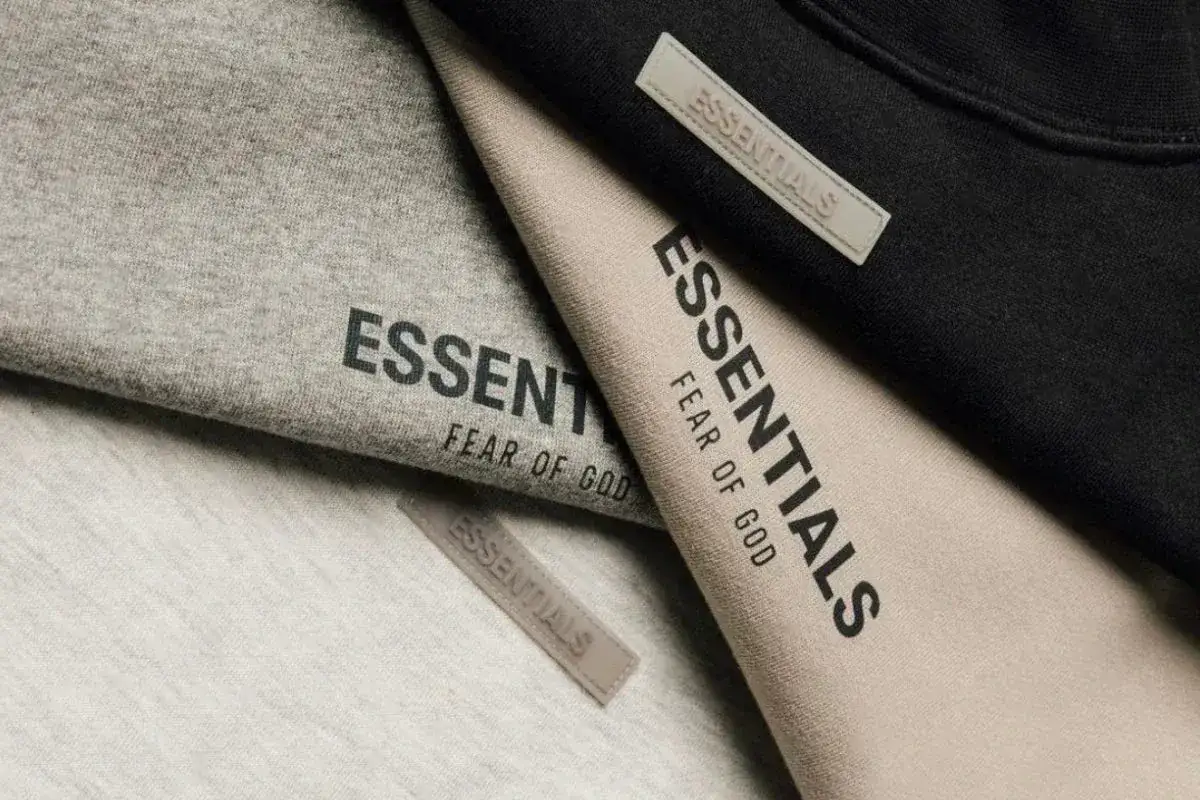 Ubrania marki Essentials, znanej z minimalistycznego stylu i jakości, w odcieniach szarości, beżu i czerni.