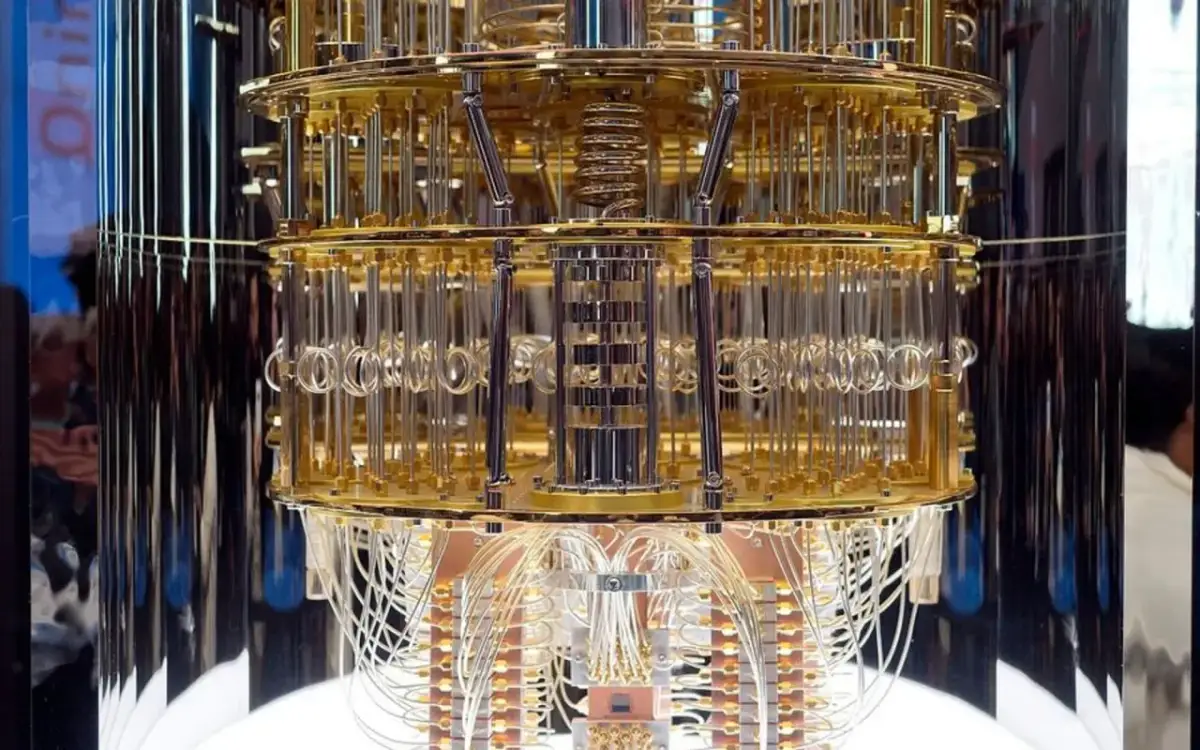 Złoty, wielopoziomowy komputer kwantowy z licznymi przewodami. Jego skomplikowana konstrukcja przypomina dzieło sztuki, a jego moc obliczeniowa może być porównywalna do szyfrowania AES 256.