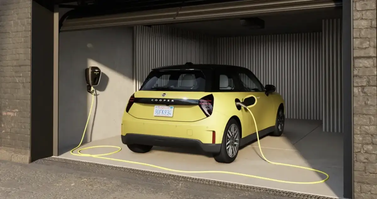 Żółty elektryczny Cooper w garażu, podłączony do ładowarki. Idealny wybór dla leasingu konsumenckiego samochodu.