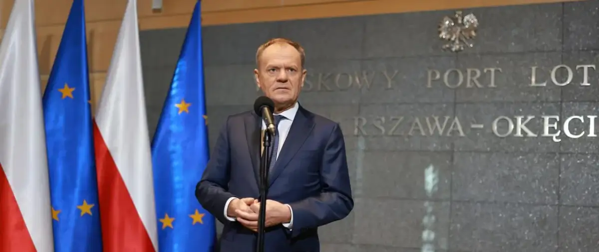 Premier Tusk, stojąc przed flagami Polski i UE, przemawia na tle napisu "Warszawa-Okęcie". Kto poparł zielony ład?