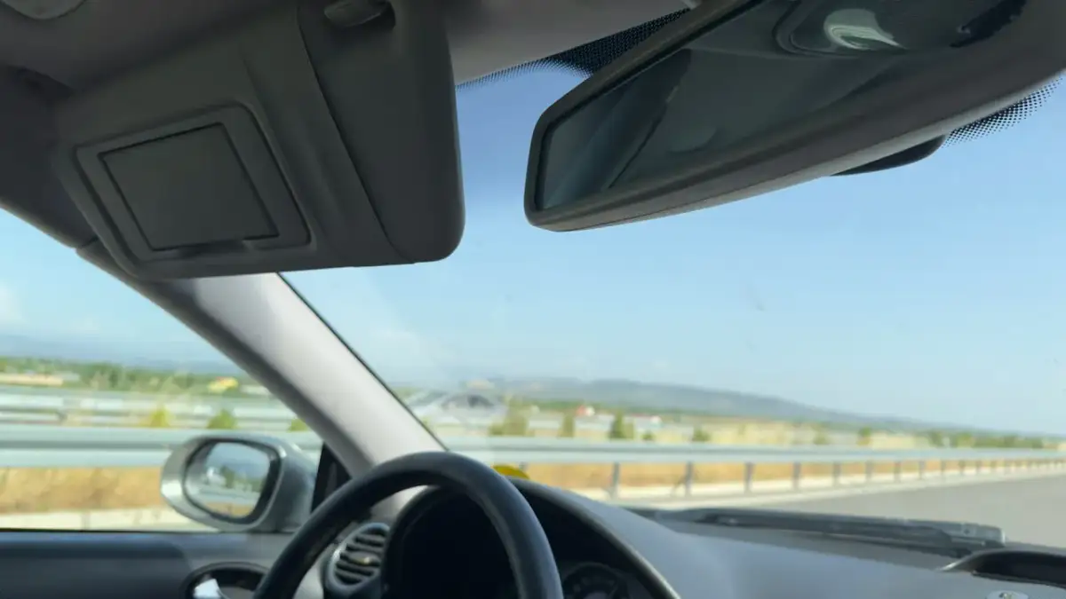 Widok z samochodu podczas podróży. Kierowca zastanawia się, jak rozliczyć delegację krajową, patrząc na drogę przed sobą.