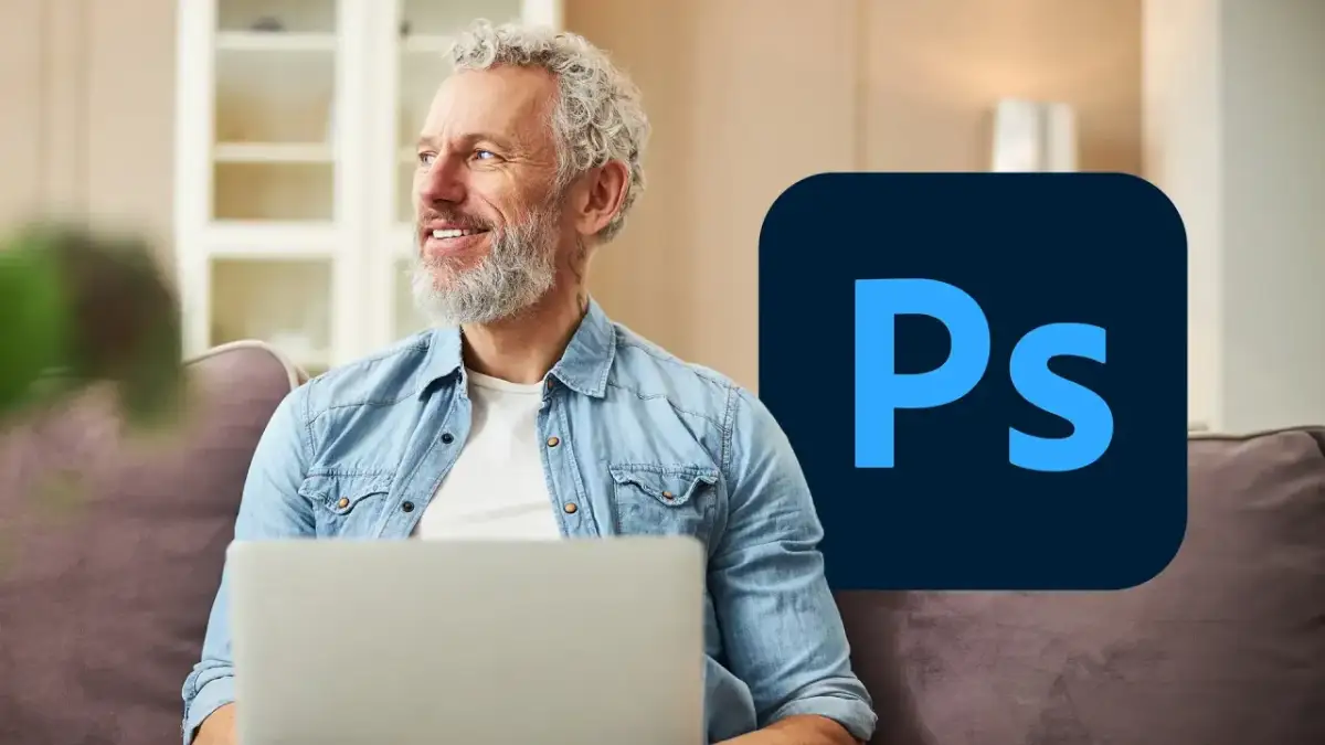 Uśmiechnięty mężczyzna z laptopem i logo Photoshop.