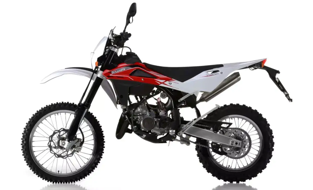 Husqvarna CR 125 dane techniczne: biało-czerwony motocykl crossowy z widocznym silnikiem i oponami terenowymi.