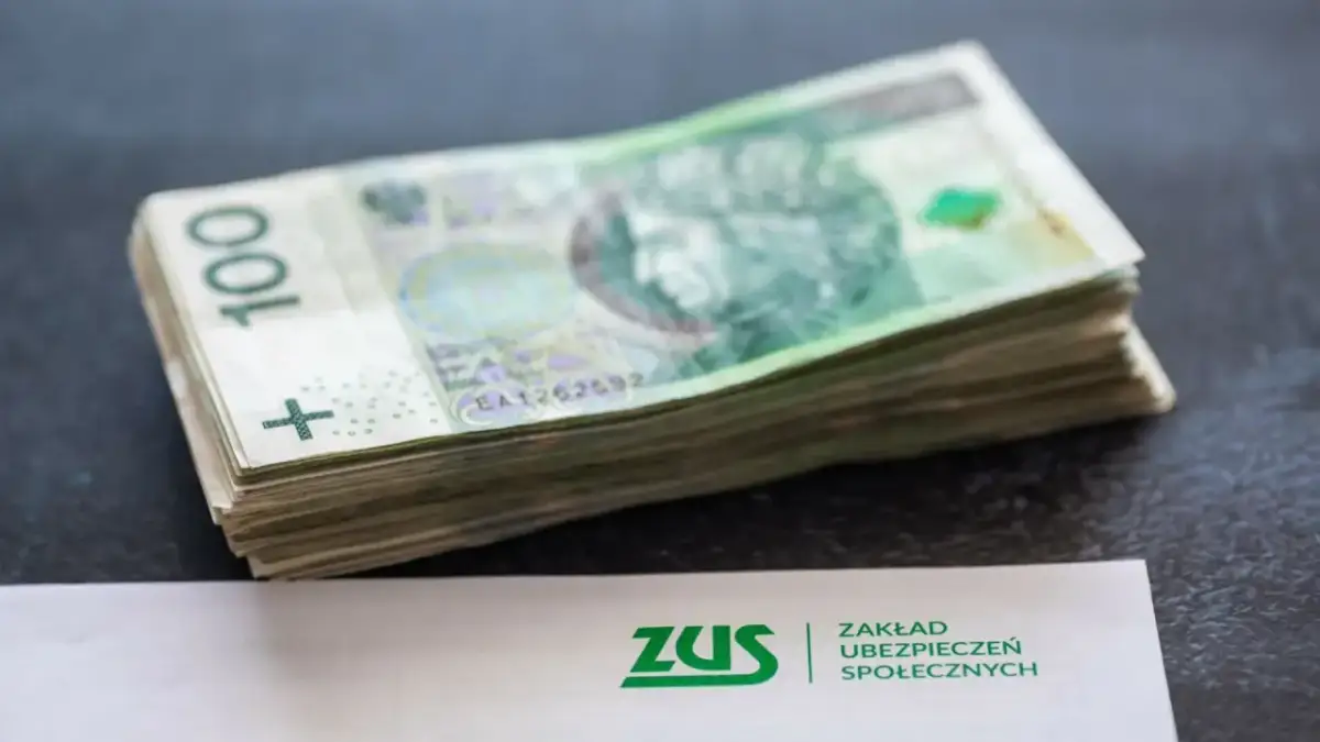 Stos banknotów 100 zł obok dokumentu ZUS. Może to symbolizować zarabianie na kontach bankowych lub oszczędzanie na przyszłość.