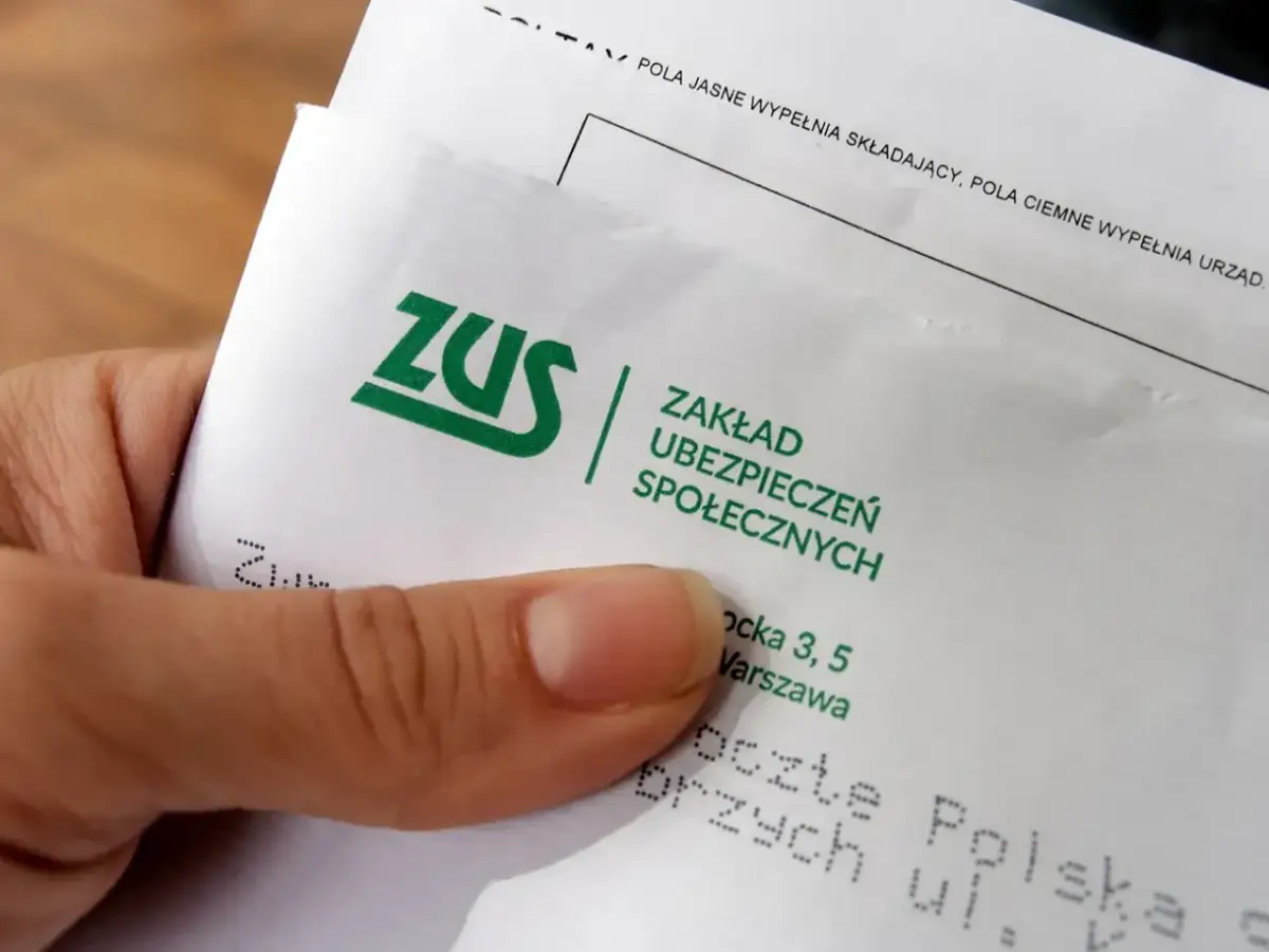 Dłoń trzyma dokument ZUS. To ważny krok w kierunku odprawy emerytalnej w małej firmie.