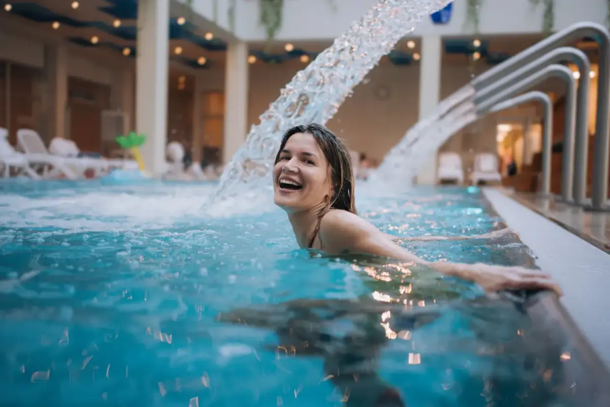 Szczęśliwa kobieta w basenie z wodospadem. Czy które termy lepsze: Bukowina czy Bania?