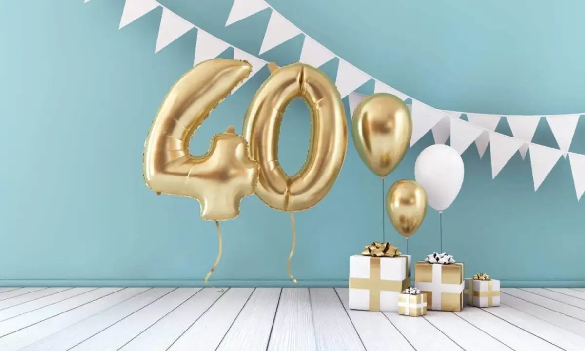 Złote balony z cyfrą 40, prezenty i girlanda tworzą idealną scenografię na wierszyk na 40 urodziny.