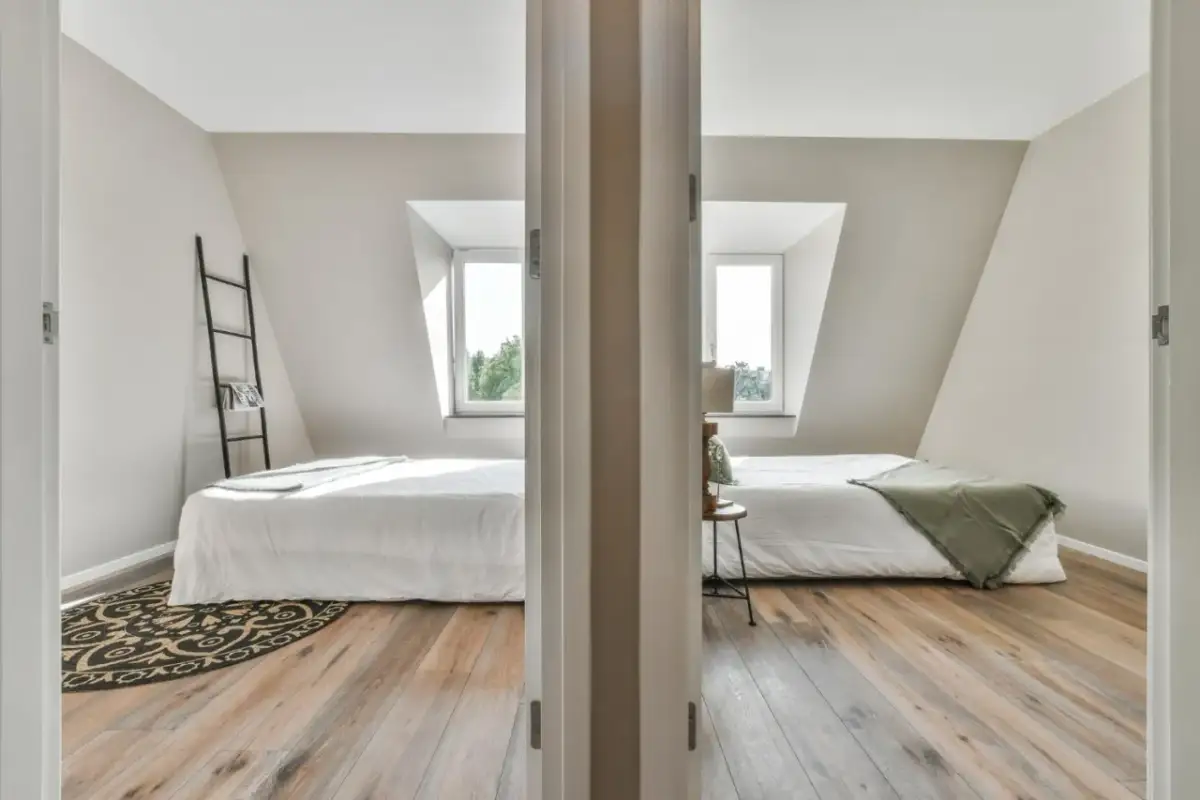 Jak podzielić pokój dzieci z jednym oknem? Dwa łóżka, każde z własnym oknem dachowym, tworzą przytulne strefy.