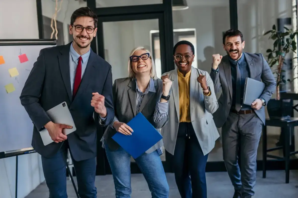 Zespół świętuje sukces, realizując strategię hoshin kanri. Radość i energia widać na ich twarzach.