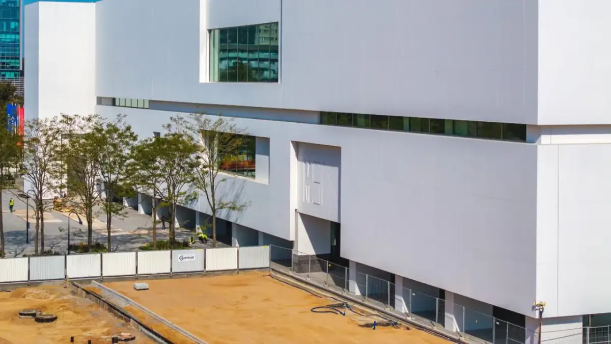 Nowoczesny budynek muzeum sztuki współczesnej w Warszawie, z białymi, geometrycznymi fasadami i dużymi oknami.