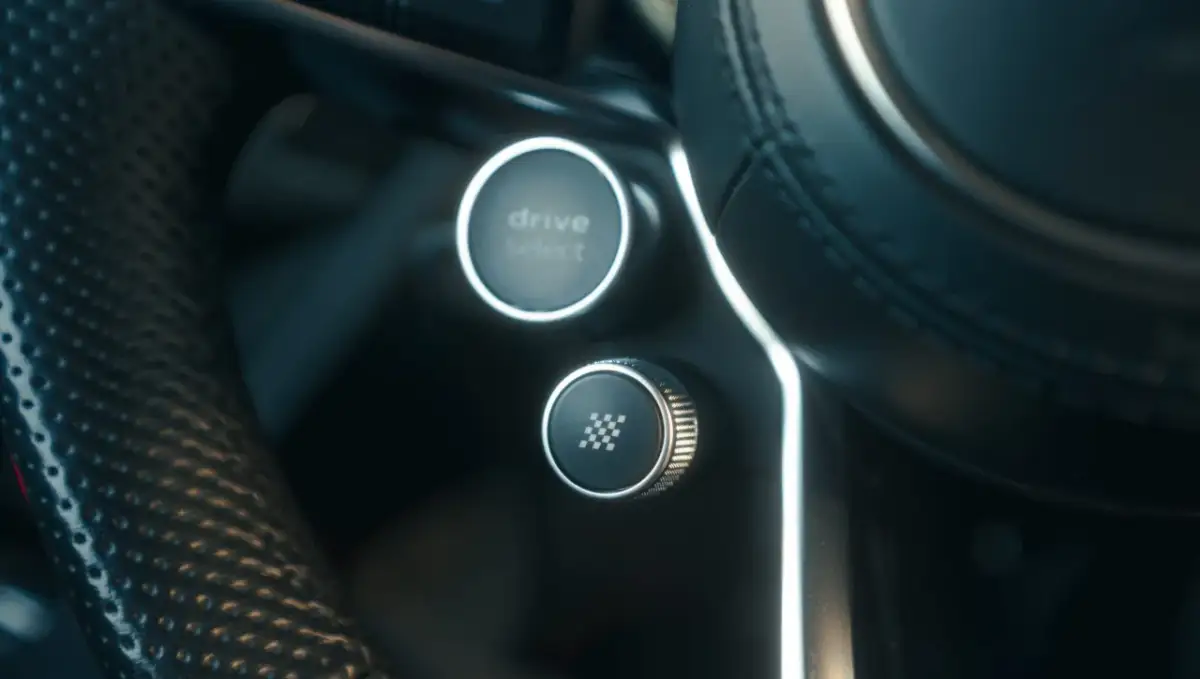 Przycisk z szachownicą na kierownicy. To jest przycisk launch control, który pozwala na maksymalne przyspieszenie.