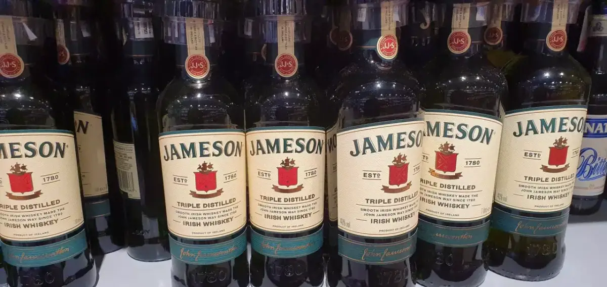 Rząd butelek Jameson Triple Distilled Irish Whiskey. Idealne na prezent lub do domowego barku, to dobre whisky z Biedronki.