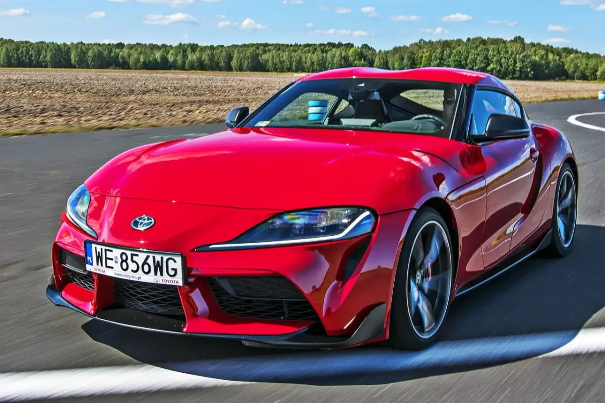 Czerwona Toyota Supra pędzi po torze. Zastanawiasz się, ile kosztuje Toyota Supra? Ten sportowy samochód robi wrażenie!