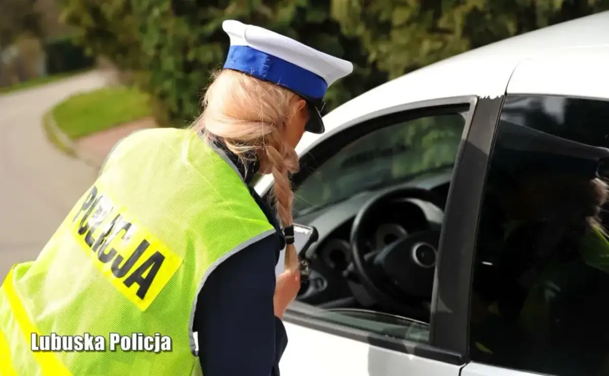 Policjantka w kamizelce odblaskowej rozmawia z kierowcą. Zastanawiasz się, na ile zabierają prawo jazdy za prędkość?