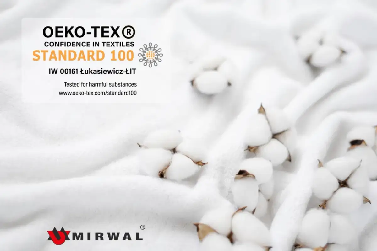 Certyfikat OEKO-TEX Standard 100 potwierdza bezpieczeństwo tkaniny. Delikatne kłębki bawełny na białym tle.