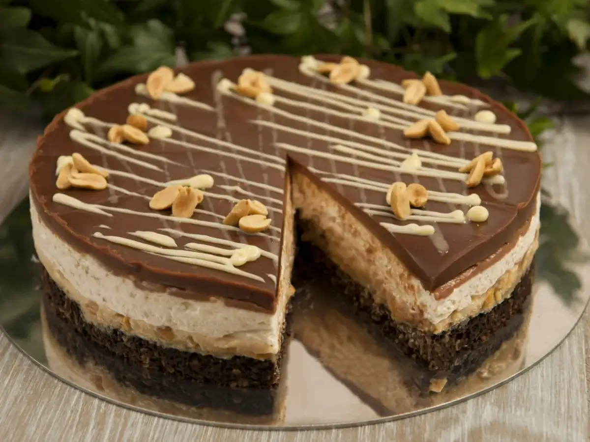 Pyszne ciasto snickers bez pieczenia z czekoladą, orzeszkami i kremem. Idealne na deser.