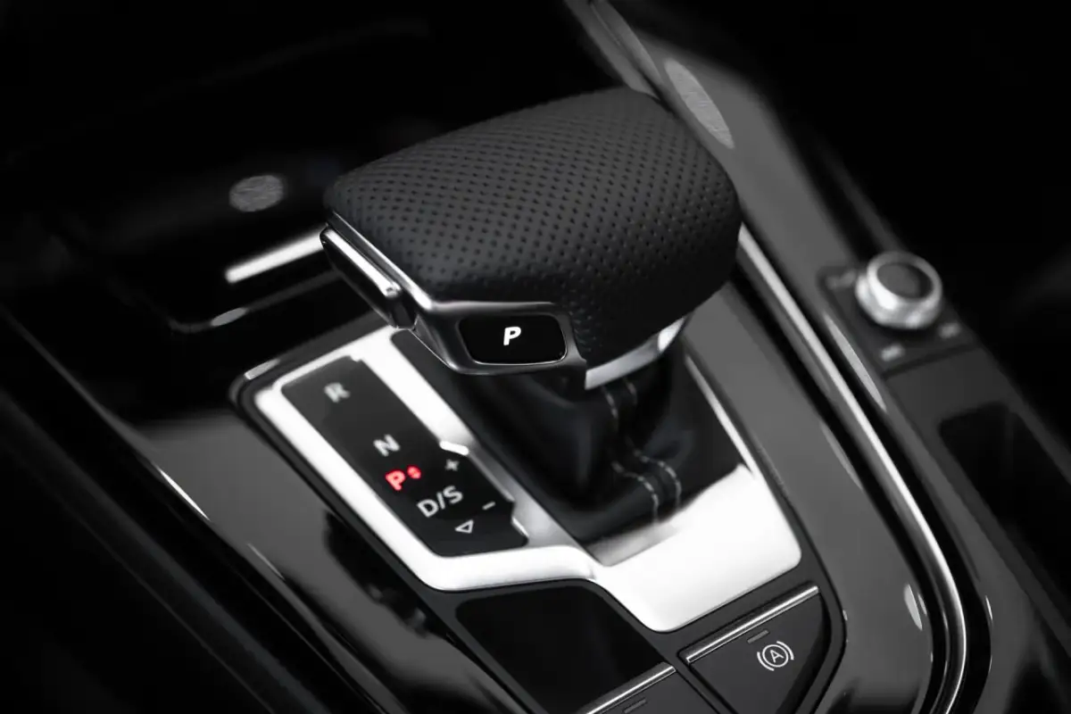 Dźwignia zmiany biegów w automacie. Czy odpalanie automatu z hamulcem czy bez? Widoczny przycisk "P" i oznaczenia biegów.