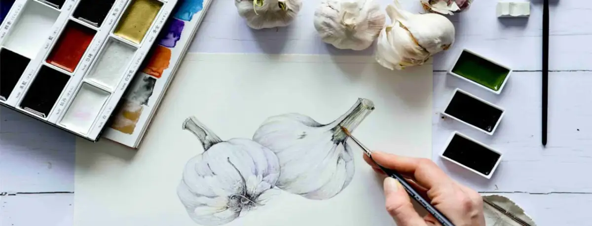Artysta tworzy akwarelowy obraz czosnku, używając palety z różnymi odcieniami. Poznaj techniki malarskie!