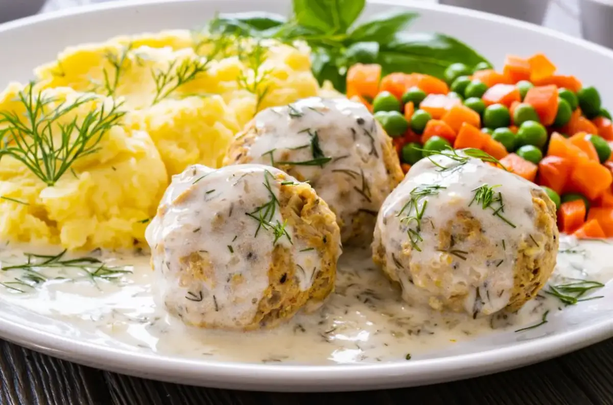 Pyszne pulpety z indyka w sosie koperkowym, podane z puree ziemniaczanym i warzywami.