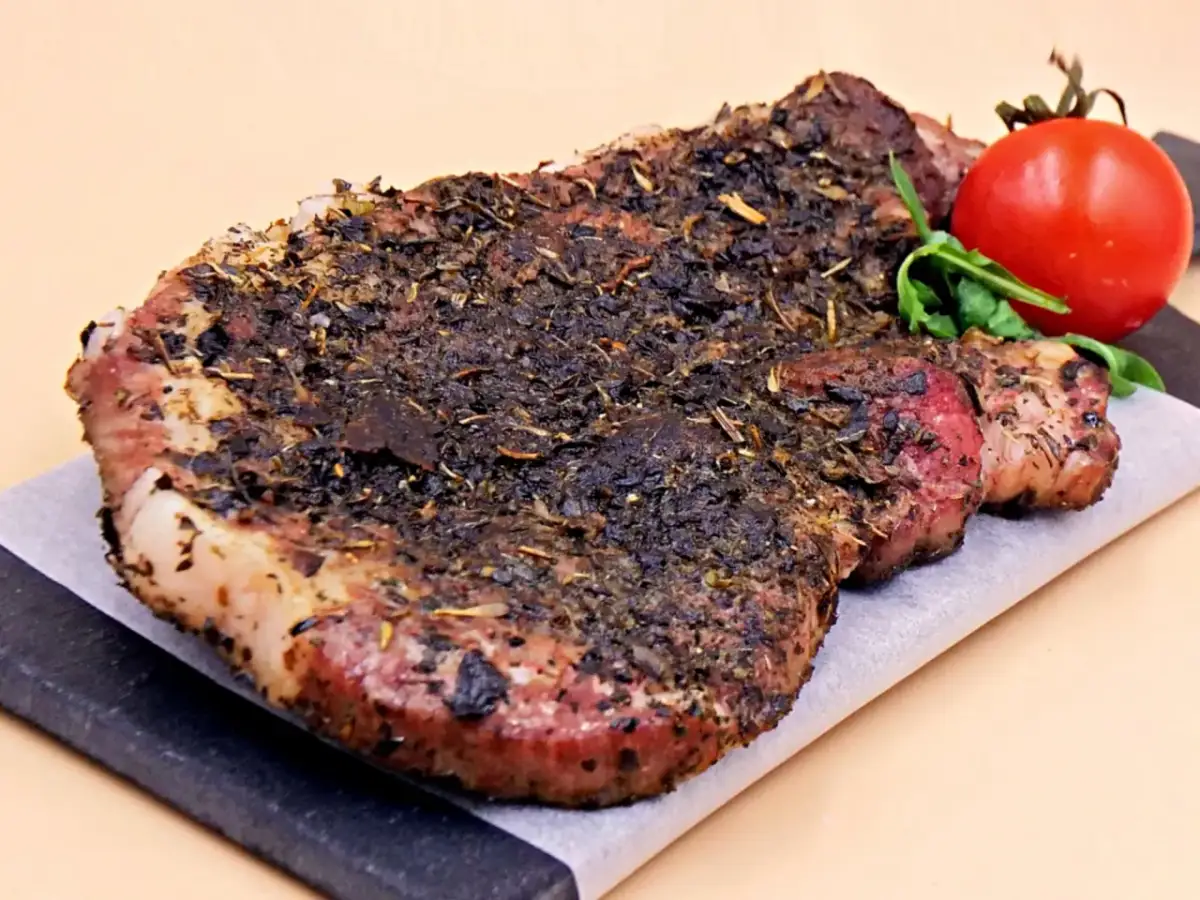 Aromatyczne potrawy z karkówki na przyjęcie: soczysty stek z ziołami i pomidorkiem koktajlowym.