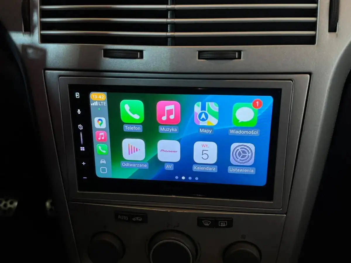 Nowe radio Android w Oplu Astra H z ekranem dotykowym i ikonami aplikacji: Telefon, Muzyka, Mapy, Wiadomości, Odtwarzane, AV, Kalendarz, Ustawienia.