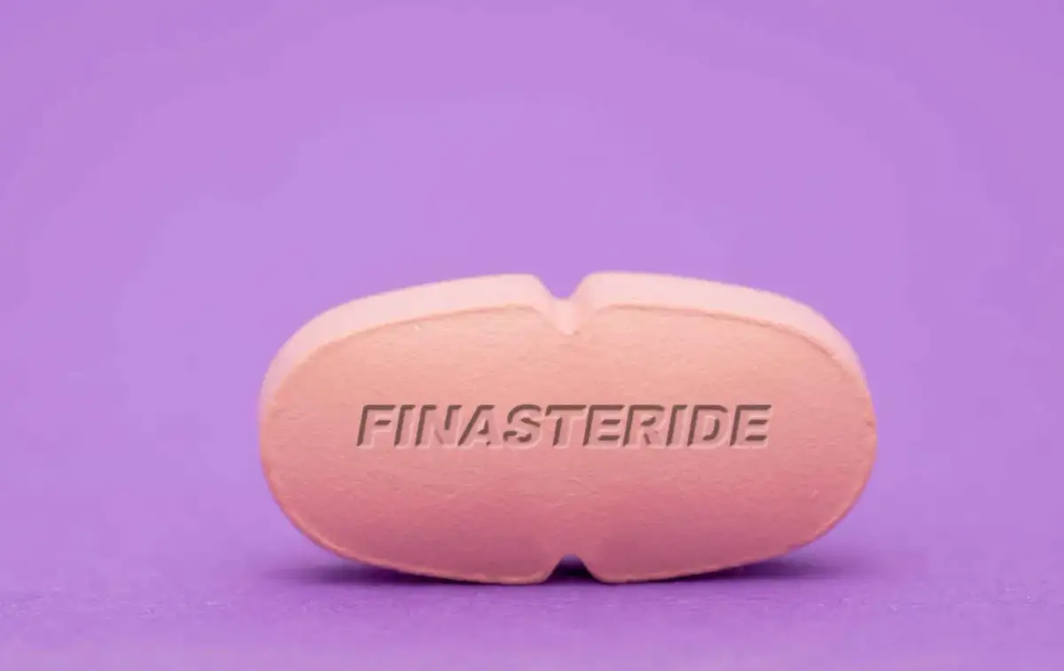 Różowa tabletka z napisem FINASTERIDE. Szukasz co na prostatę bez recepty? To może być rozwiązanie.