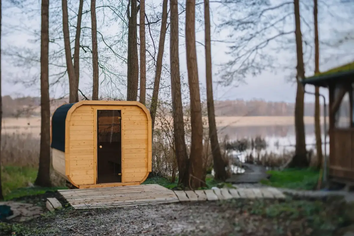Drewniana sauna w lesie nad jeziorem.