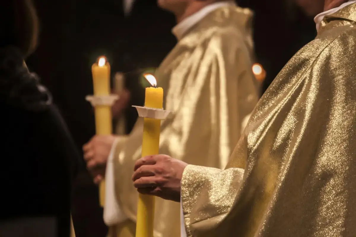 Uroczystość bierzmowania, chrzestny trzyma zapaloną świecę. Zastanawiasz się, ile dać na bierzmowanie jako chrzestny?