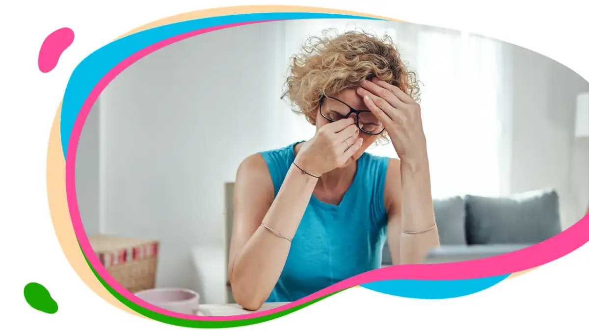 Kobieta z bólem głowy i zatokami, trzymająca się za czoło i nos. Objawy kataru zatokowego mogą być uciążliwe.