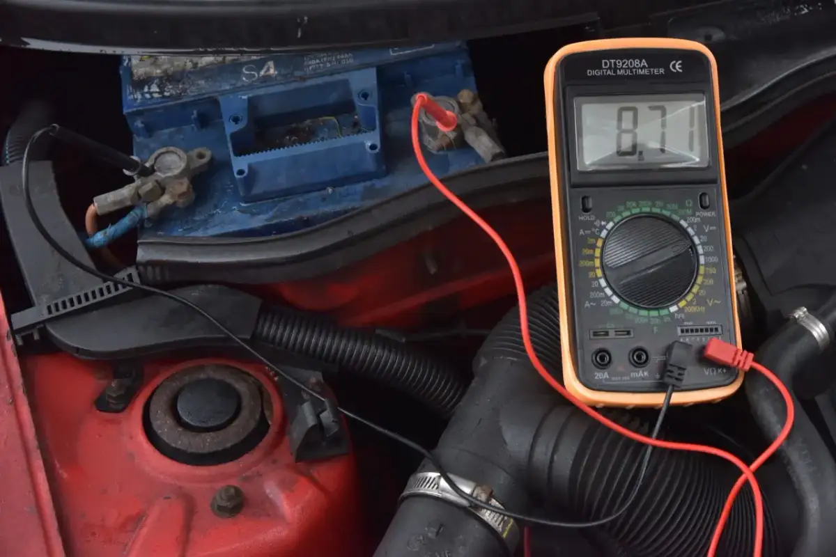 Sprawdzanie akumulatora multimetrem, by dowiedzieć się, jak odpalić auto z rozładowanym akumulatorem. Wynik 8.71V wskazuje na problem.