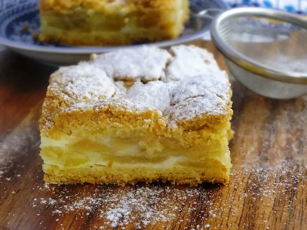 Pyszna szarlotka z kisielem, posypana cukrem pudrem, kusi swoim wyglądem.