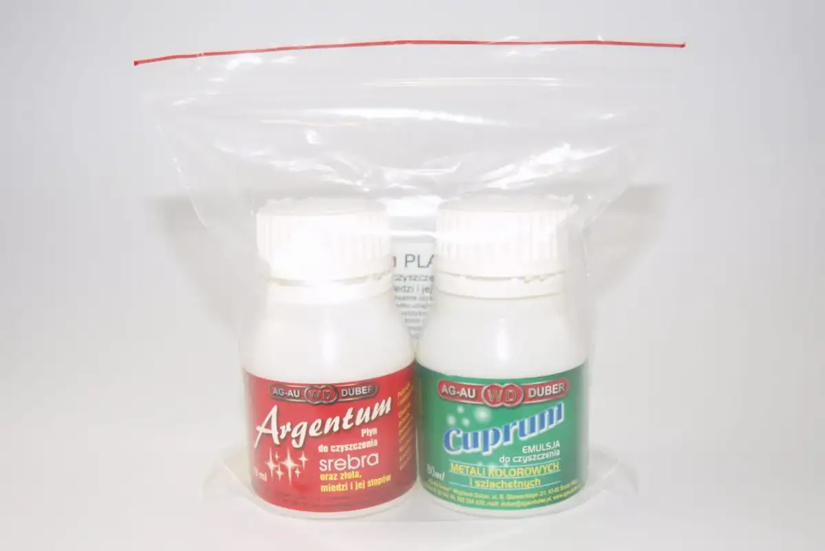 Dwie butelki płynów do czyszczenia srebra i metali kolorowych w plastikowym opakowaniu.