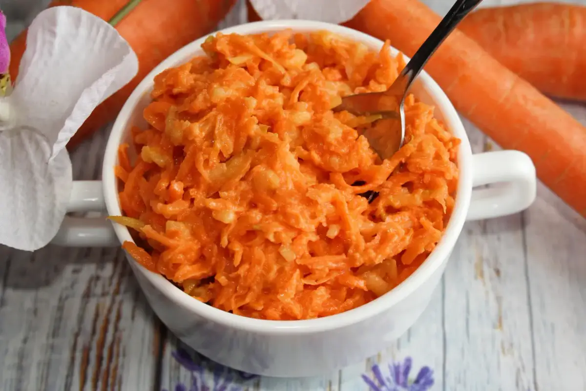 Tarta marchewka z jabłkiem i chrzanem w białej miseczce. Różnica smaków między słodką a ostrą surówką.