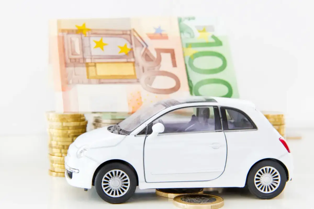 Biały samochodzik na monetach i banknotach euro. Zastanawiasz się, co z leasingiem po zamknięciu firmy?