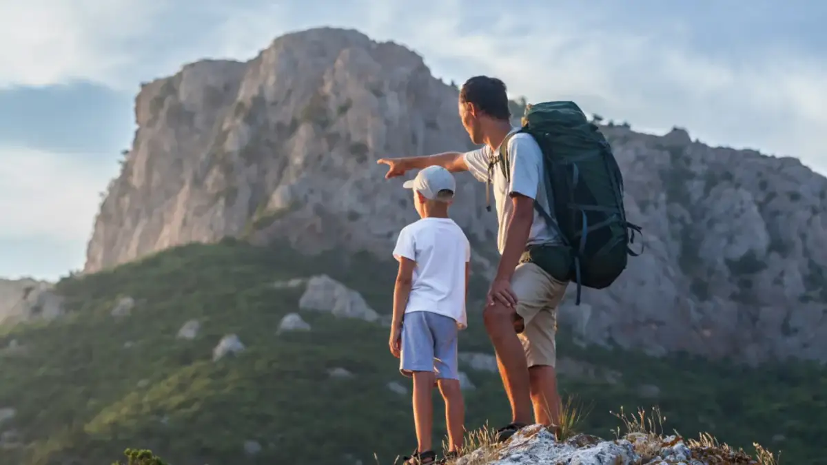 Ojciec z synem patrzą na góry. Zastanawiają się, ile kosztuje noc w schronisku w Tatrach.