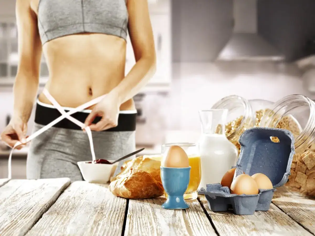 Kobieta mierzy talię, obok zdrowe śniadanie: jajka, płatki, mleko, sok. Idealny jadłospis na dieta 1 kg tygodniowo.