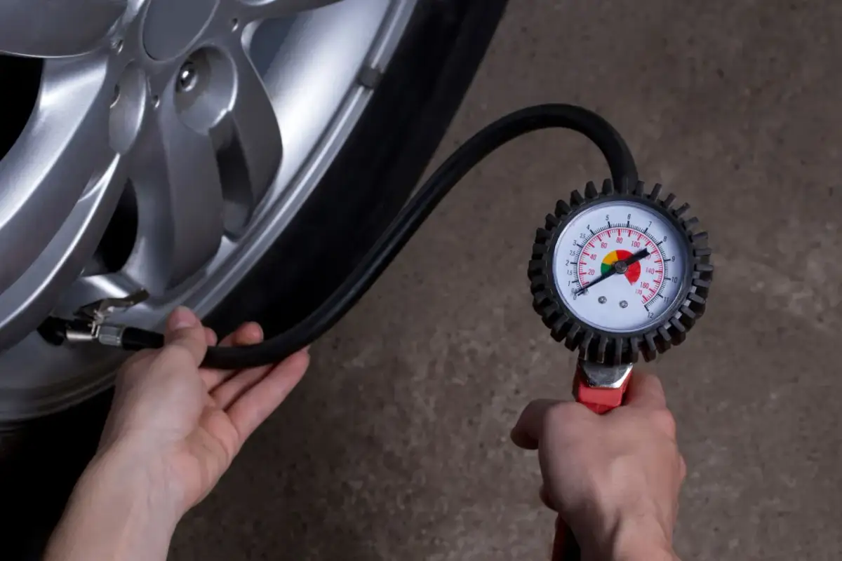 Sprawdzanie, jakie ciśnienie w oponach jest prawidłowe, za pomocą manometru. Wskaźnik pokazuje optymalne wartości.