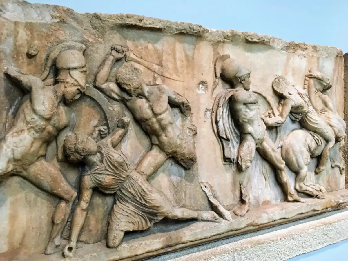 Kamienna płaskorzeźba przedstawia scenę walki, być może bitwę z udziałem trzech wojowników. Dzieło nawiązuje do stylu Fidiasza.