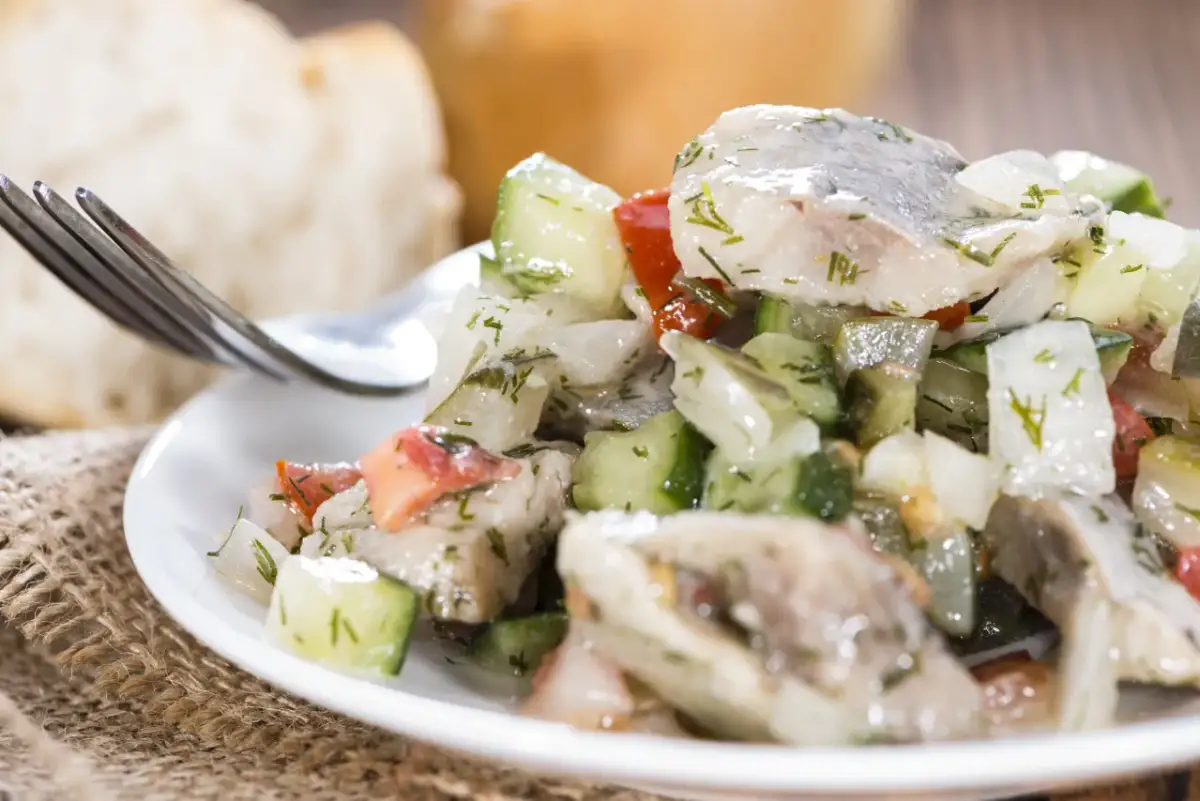 Sałatka śledziowa z ogórkiem i pomidorem, idealna na szybki obiad. Oto jak zrobić sałatkę śledziową.