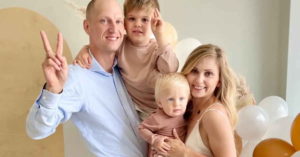 Katarzyna z mężem i dziećmi, uśmiechnięci, w otoczeniu balonów.