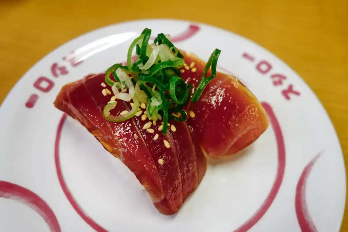 Dwa kawałki tuńczyka na ryżu, posypane sezamem i szczypiorkiem. Zastanawiasz się, ile kosztuje sushi w Japonii?
